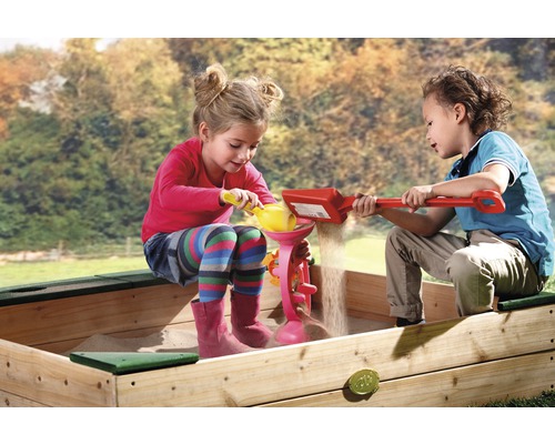 Deux enfants jouent avec du sable dans un bac à sable avec des jouets de sable.