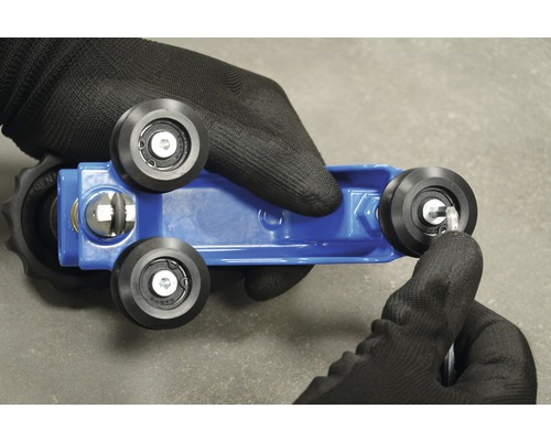 Support d''outil bleu avec rouleaux noirs et main avec gant de travail