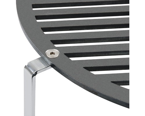 Vue détaillée d''une grille de barbecue ronde et noire avec des barreaux et un pied argenté