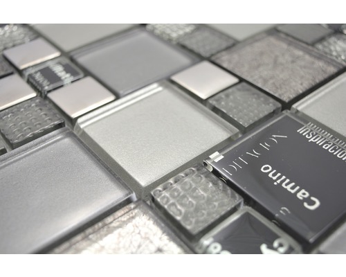 Gros plan de carreaux de mosaïque en verre dans différentes nuances de gris et textures.