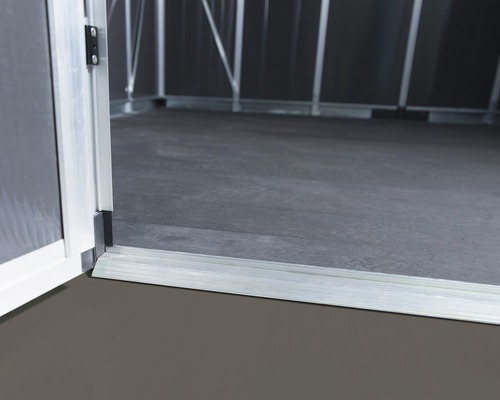 Gros plan d''une porte ouverte donnant sur un abri de jardin avec un cadre en aluminium et un sol sombre