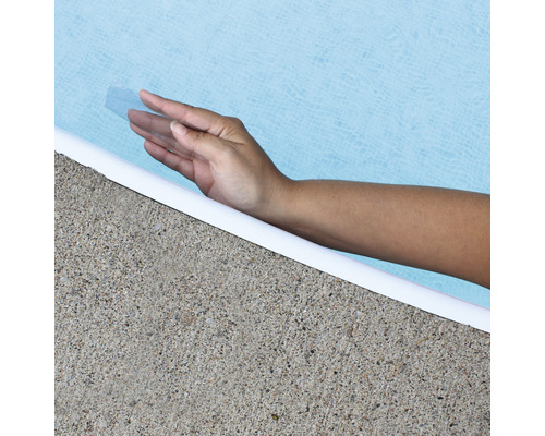 Une main touche l''eau de la piscine au bord du bassin