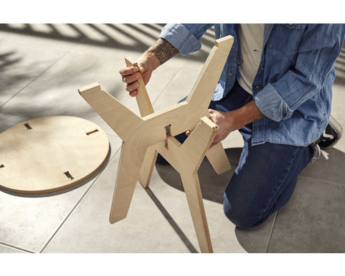 Montage d''une table d''appoint en bois avec plateau rond et piètement à trois pieds