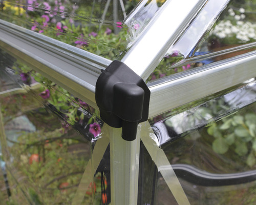 Gros plan sur le coin d''une serre avec un cadre argenté et une pièce de connexion noire.