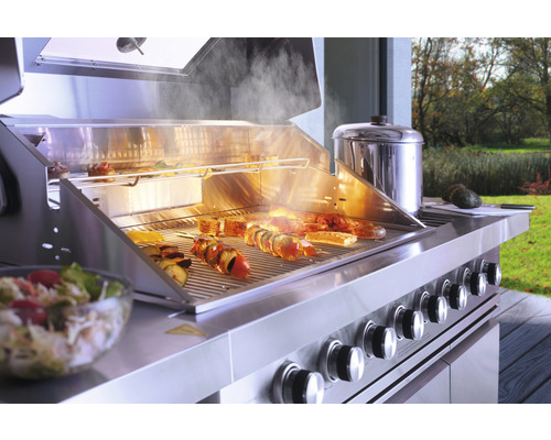 Edelstahl Grill mit Speisen auf dem Grillrost und Zubehör