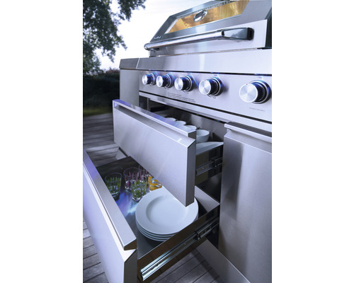 Edelstahl-Aussenküche mit geöffneten Schubladen, gefüllt mit Geschirr und Gläsern.