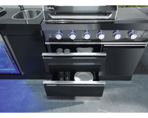 Detailansicht eines schwarzen Outdoor-Grills mit geöffneten Schubladen, die Geschirr enthalten