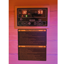 Bedienfeld einer Sauna mit Temperaturanzeige und Sicherheitshinweisen