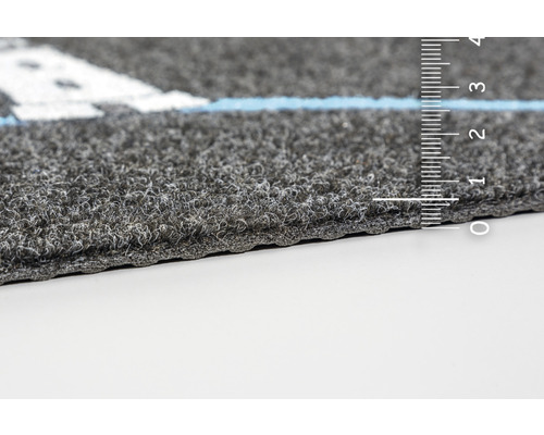 Nahaufnahme eines grauen Teppichs mit Massband zur Messung der Dicke
