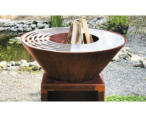 Feuerstelle aus Metall mit Holz auf einem Sockel im Freien