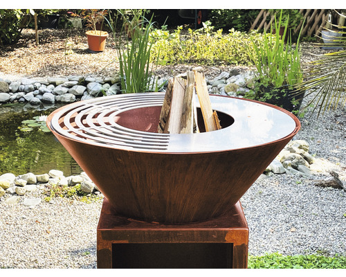 Feuerschale aus Metall mit Holz auf einem Sockel im Garten