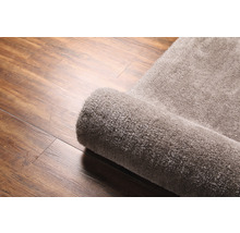 Tapis enroulé sur plancher en bois