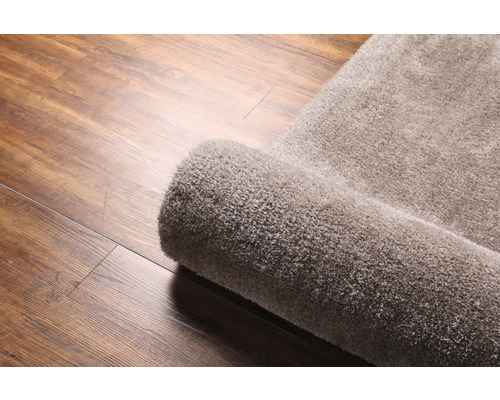 Tapis enroulé sur plancher en bois