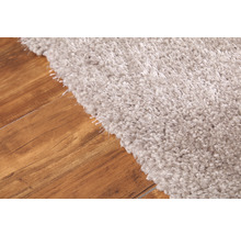 Vue détaillée d''un tapis shaggy de couleur claire sur un plancher en bois