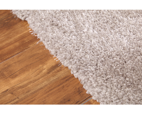 Vue détaillée d''un tapis shaggy de couleur claire sur un plancher en bois