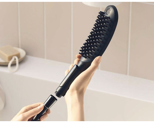 Pomme de douche avec brosse et raccord de tuyau en main