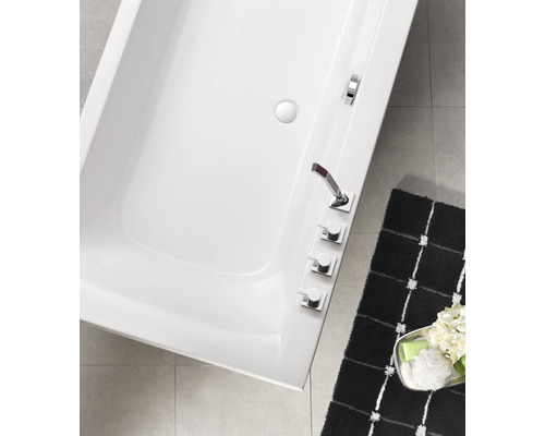 Aufnahme von oben einer weissen Badewanne mit Armaturen und einer Badematte