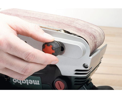 L''opérateur règle la ponceuse à bande