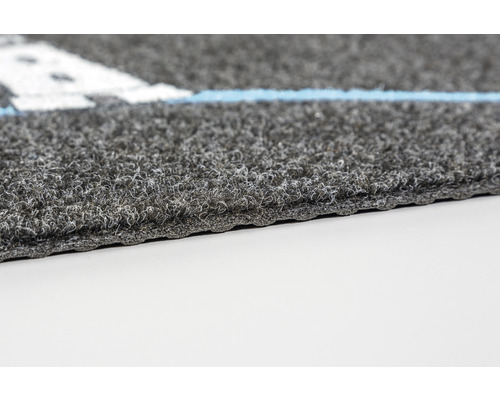 Detailaufnahme einer grauen Fußmatte mit weißem Aufdruck und blauer Linie
