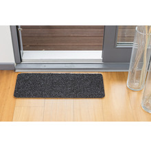 Tapis de sol devant une porte de terrasse sur un plancher en bois