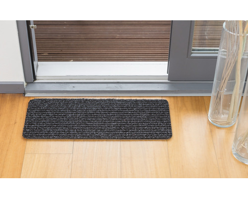 Tapis de sol devant une porte de terrasse sur un plancher en bois