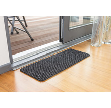 Tapis de sol devant une porte de terrasse sur un plancher en bois
