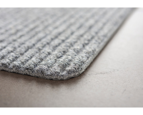 Vue détaillée d''un paillasson gris à structure côtelée.