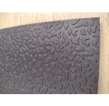 Tapis en caoutchouc noir avec motif irrégulier.