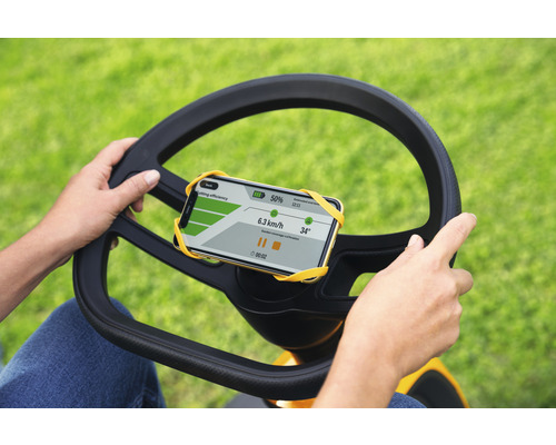Personne utilisant un tracteur de pelouse avec un support de smartphone sur le volant