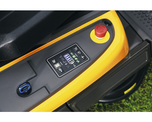 Gros plan du panneau de commande d''un tracteur de pelouse avec affichage numérique et bouton d''arrêt d''urgence