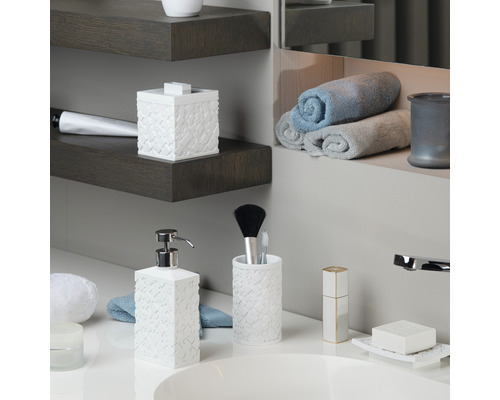 Badezimmer mit Waschbecken, Seifenspender, Zahnbürstenhalter, Seifenschale und Handtüchern