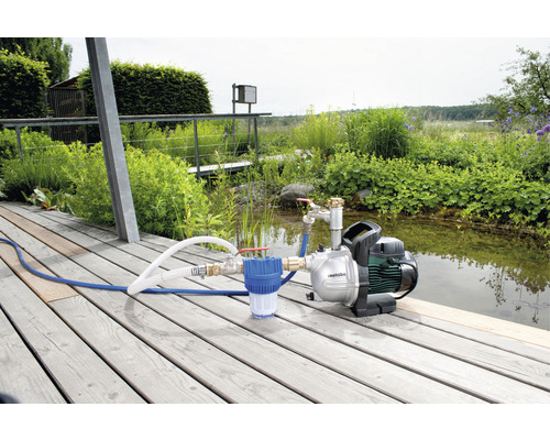 Metabo Hauswasserwerk auf Holzterrasse mit Teich im Hintergrund
