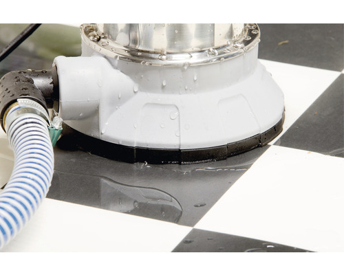 Gros plan d''une pompe submersible avec tuyau sur un motif en damier