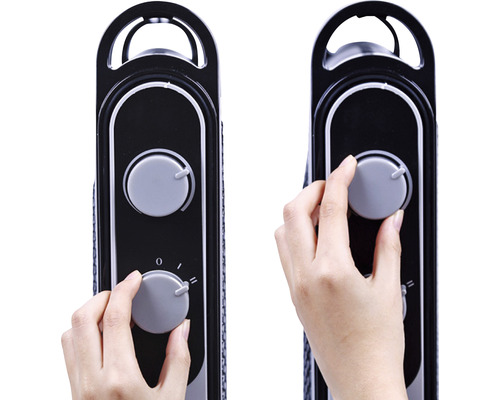 Detailaufnahme einer Hand, die einen Drehknopf an einem Heizkörper reguliert.