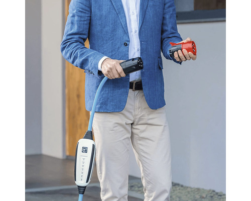 Mann hält ein Elektroauto-Ladekabel mit Stecker in der Hand