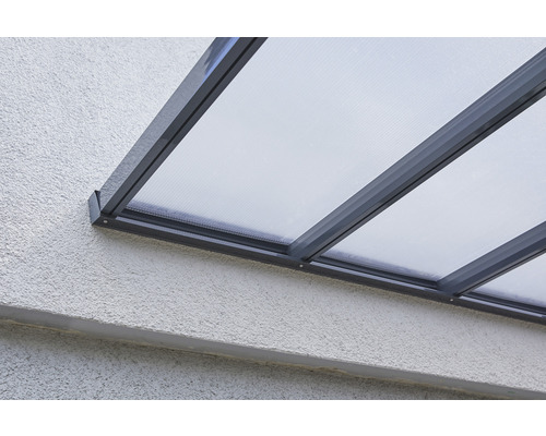 Gros plan d''un toit de terrasse avec des panneaux transparents et un cadre sur un mur.