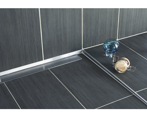 Salle de bains avec sol carrelé, caniveau de douche en acier inoxydable et objets de décoration