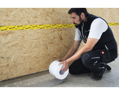 Handwerker verarbeitet SIGA Sicrall Klebeband im Innenbereich.