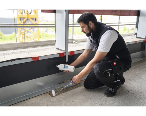 Handwerker verwendet eine Dichtstoffrolle und eine Flasche Dichtstoff für Bauarbeiten