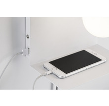 Smartphone connecté avec un câble de charge sur une étagère
