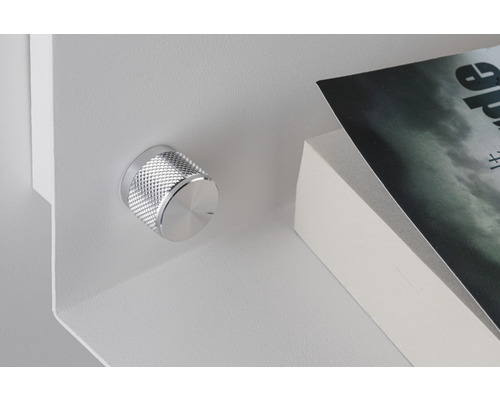 Detailansicht eines Regals mit Drehknopf und Buch