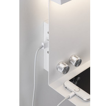Applique murale blanche avec commandes et un téléphone portable branché à un câble de charge