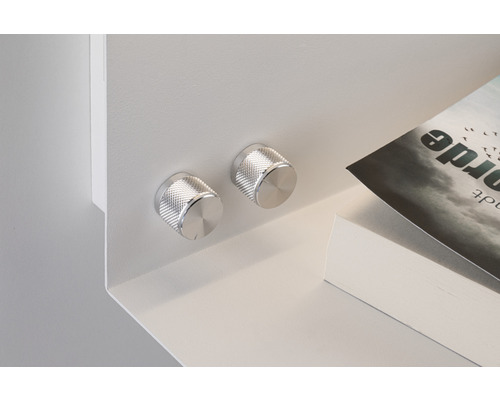 Detailansicht eines weissen Regals mit zwei silberfarbenen Drehknöpfen