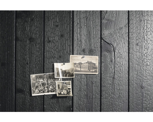 Schwarze Holzvertäfelung mit angehefteten Fotos