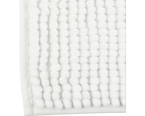 Gros plan d''un tapis de bain blanc avec structure à picots