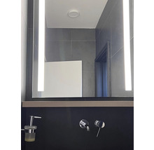 Salle de bain moderne avec miroir éclairé et robinetterie