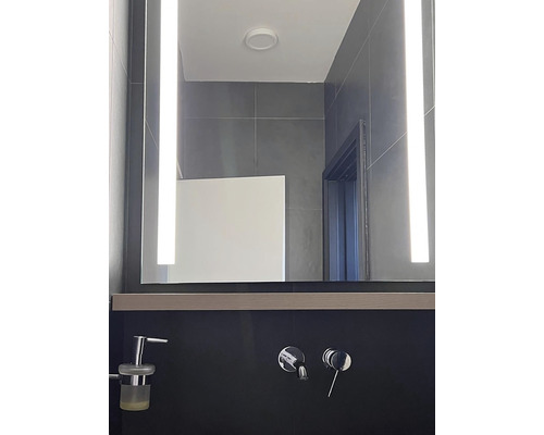 Salle de bain moderne avec miroir éclairé et robinetterie