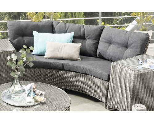 Salon de jardin avec surface en rotin, coussins et oreillers gris sur une terrasse