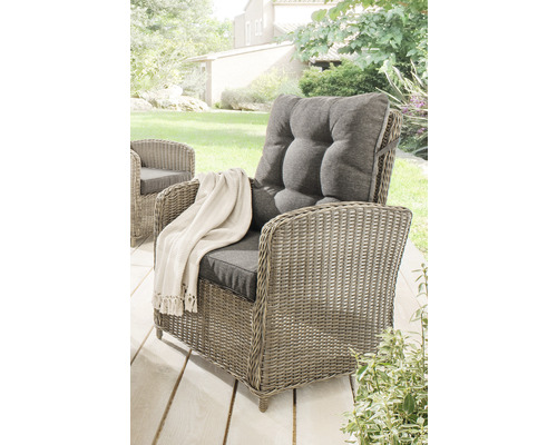 Mobilier de jardin : fauteuil en rotin avec coussin et jeté sur une terrasse