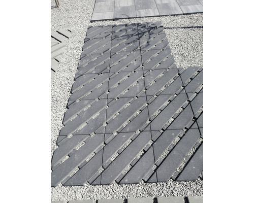 Pose de dalles alvéolées sur gravier pour allée de jardin.